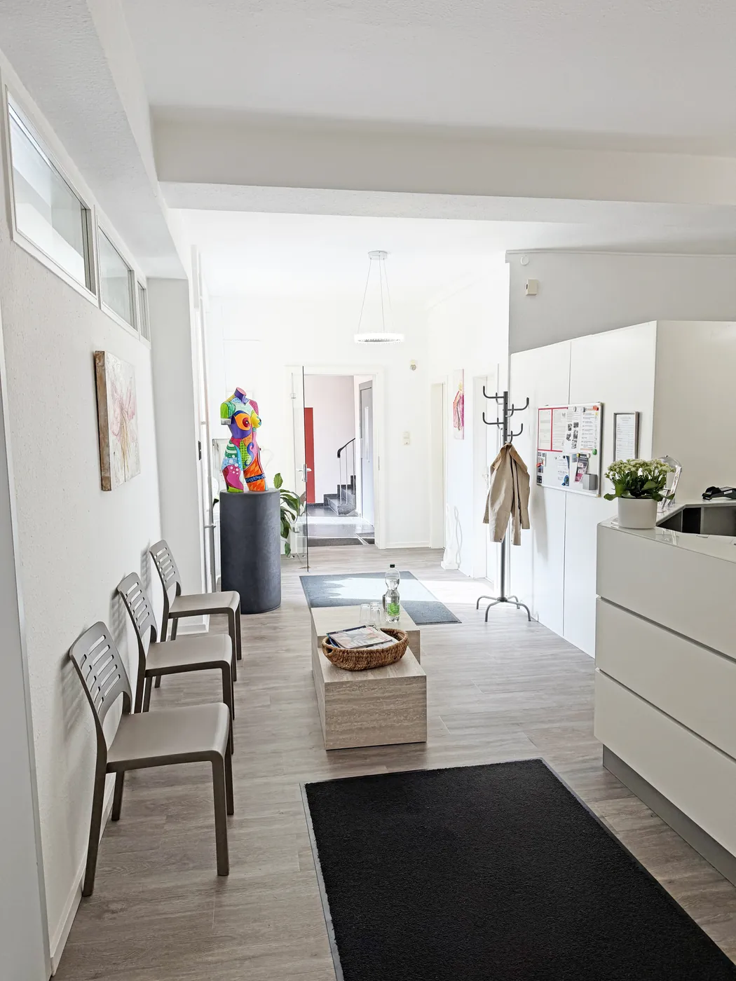 Wartebereich mit Sitzgelegenheiten und Garderobe neben dem Empfang der Praxis in Hagen